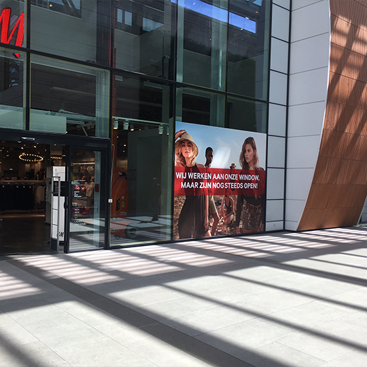 Gepersonaliseerde raamsticker aankondiging werken aan winkel H&M